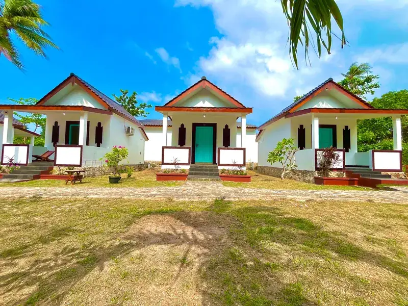 Tiga bangunan kamar putih dengan atap merah bata